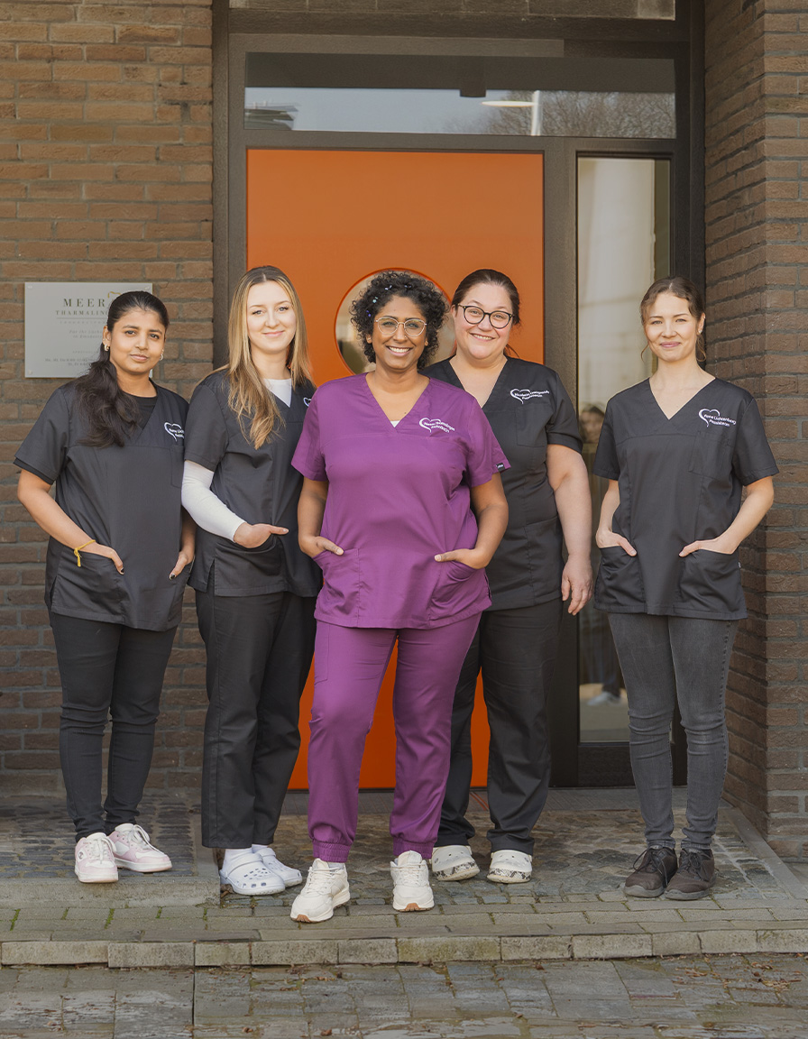 Meera Tharmalingam mit ihrem Praxisteam vor der Zahnarztpraxis in Emsdetten